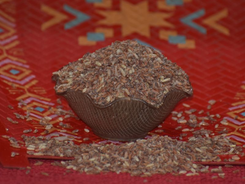 বাটিতে ও চারপাশে ছড়ানো লাল চালের দানা